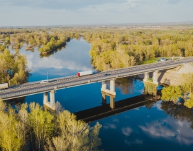 semi driving over a bridge over a river