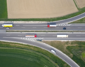 Red, yellow and white buses driving down a highway