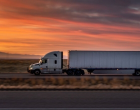 Semi truck on road with sunset