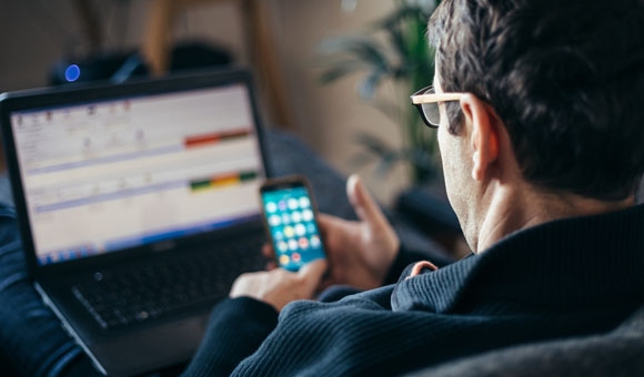 employee working remotely on a laptop and smartphone app powercommand cloud