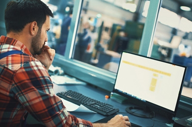 Mann, der am Computer seines Geschäfts sitzt
