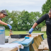 Employees painting a bench blue