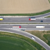 Красные, желтые и белые автобусы едут по шоссе