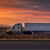 Semi truck on road with sunset