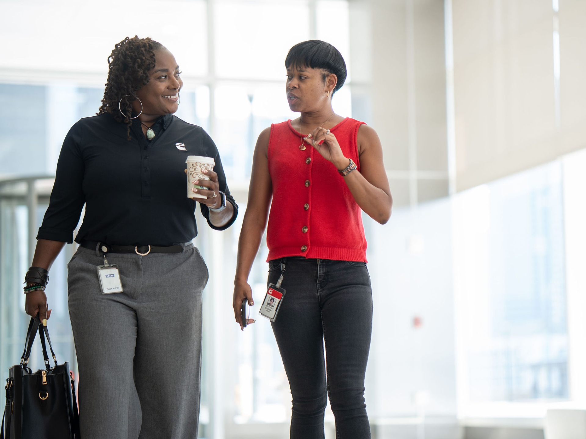 Meko walks with a colleague while talking in a Cummins office building.