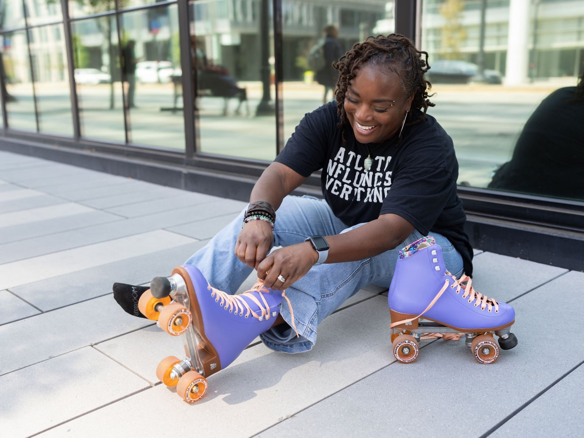Meko ties her roller skates outdoors in Atlanta before skating.