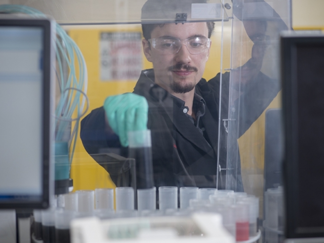 a Cummins laboratory worker handles samples in the lab. a Cummins laboratory worker handles samples in the lab.