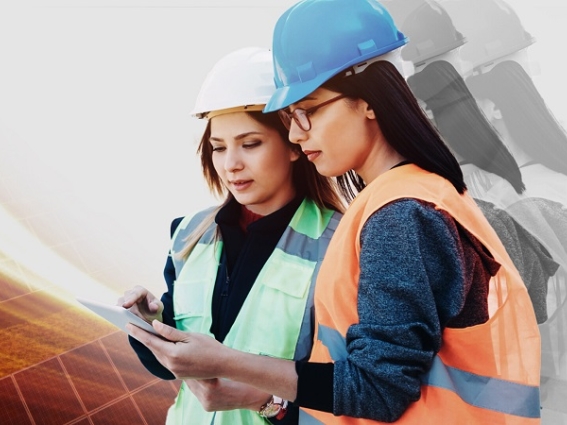 Women in construction garb look at information on a clipboard