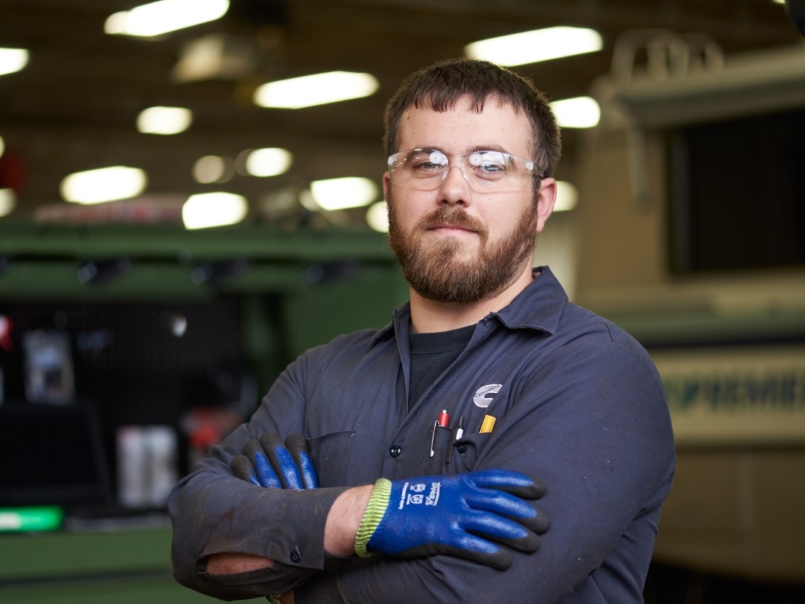 Servisní technik společnosti Cummins se založenýma rukama