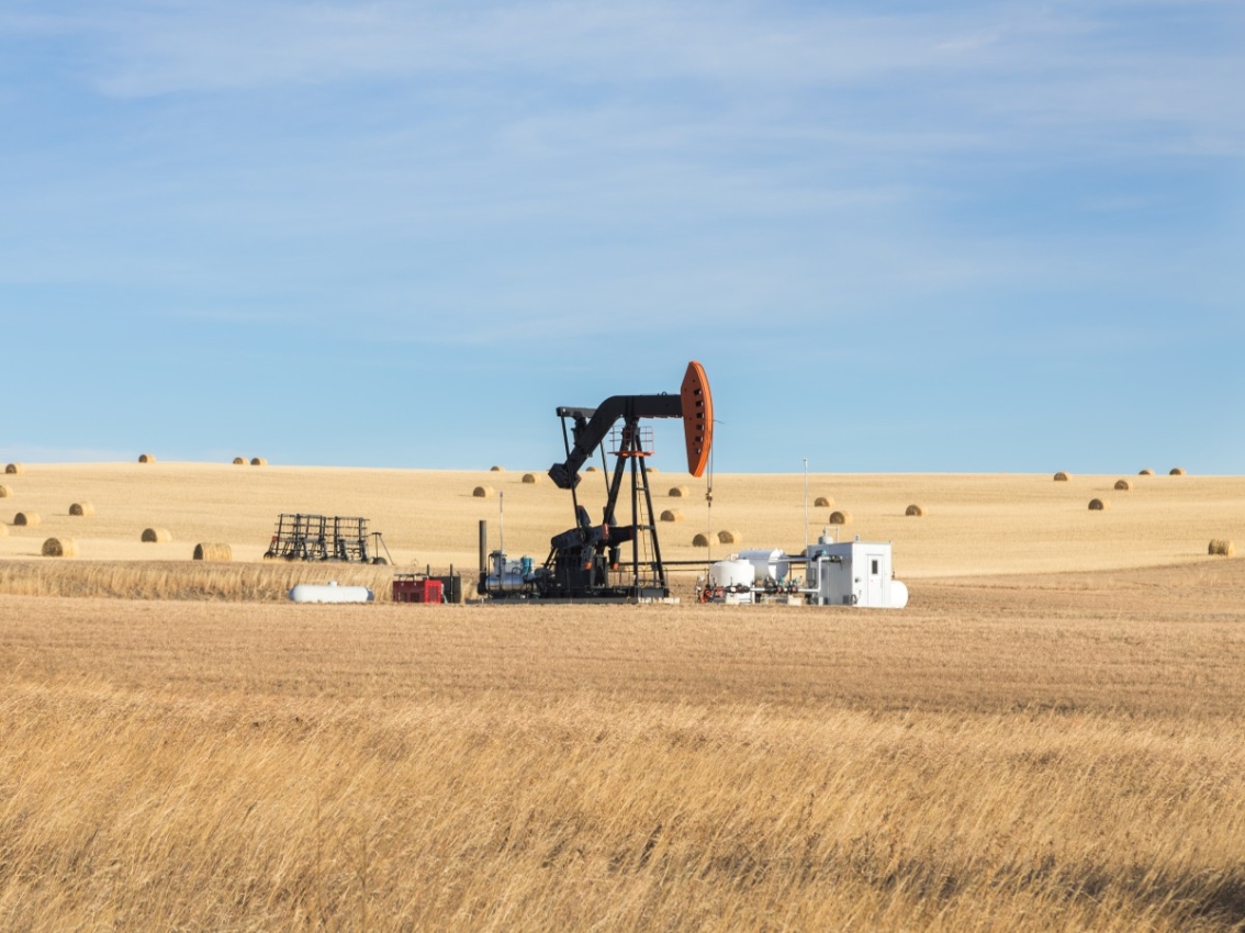 oil pump jack station in dry grass field